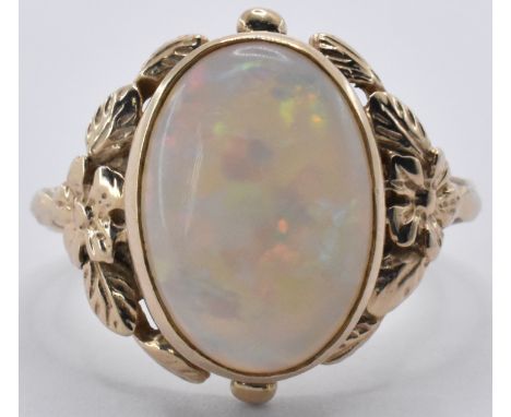 A 9ct gold ring being set with an oval opal cabochon having decorative moulded floral shoulders. Marked 375. Weight 4.2g. Siz