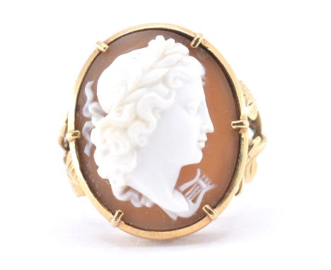 An 18ct gold Art Nouveau cameo ring. The ring set with a carved cameo head of a maiden, with harp, set within a claw and beze