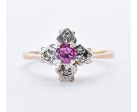 A hallmarked 9ct gold ring set with a round cut ruby to the centre set with four diamonds in marquise shaped white metal moun