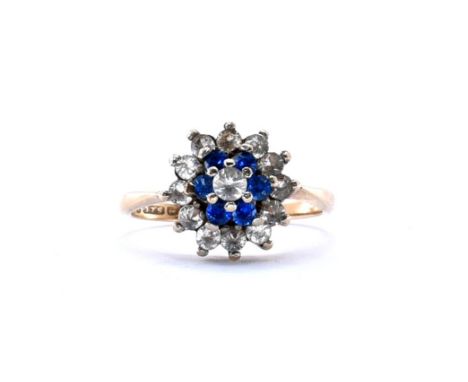 A 9ct gold hallmarked cluster ring having a central round cut white stone surrounded by a halo of six blue stones and a furth