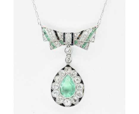 A 1930's Art Deco platinum emerald and diamond pendant necklace having a fine link chain with a bow shaped pendant with a tea