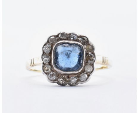 A 19th Century gold and blue and diamond stone ring being set with a central cushion cut blue stone with a halo of round cut 