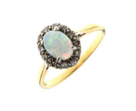 Opal set dress ring within a diamond border, the shank stamped 18ct, size M½, 3.1g approx   Condition: 