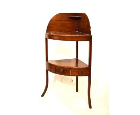 George III mahogany bowfront corner washstand having a shaped splashback with shelf over two bowfront shelves, the lower fitt