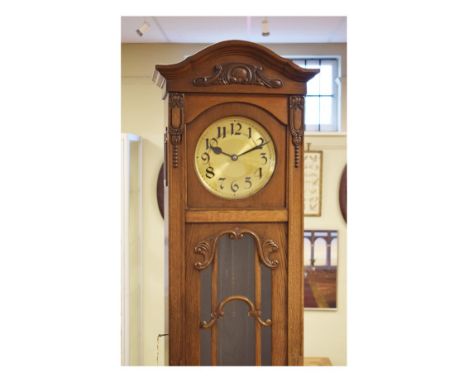 Early 20th Century oak longcase clock having circular brass dial with Arabic numerals, a glazed door, 215cm high   Condition: