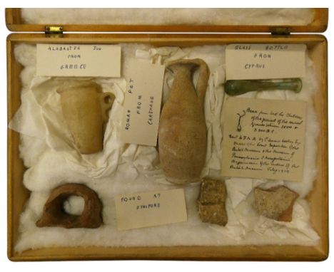 A collection of antiquities, to include a Roman pottery flask from Carthage and a glass bottle from Cyprus.