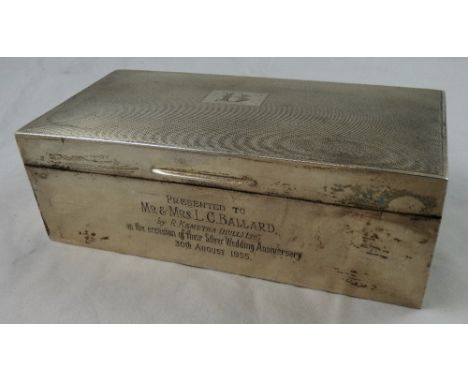 A silver presentation cigarette box, the engine turned lid to plain sides, the front with an inscription, opening to reveal t