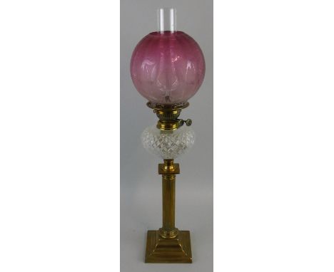 A Victorian brass and glass pedestal oil lamp, the etched ruby glass bowl mounted on a reeded column, height 70 cm.