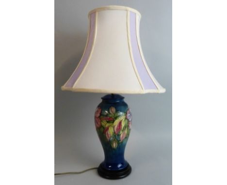 A Moorcroft 'Hibiscus' pattern tubeline decorated baluster lamp base, on dark blue ground, impressed marks, signed and with p