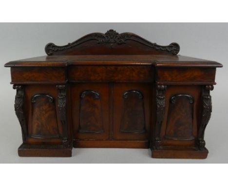 A George IV flame mahogany tea caddy modelled as a sideboard, circa 1825, of inverted breakfront form, with foliate carved su