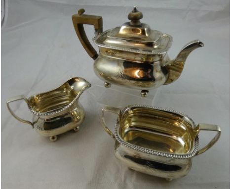 A Victorian silver three piece tea service, London 1895, of baluster form with a gadrooned border, comprising tea pot, sugar 