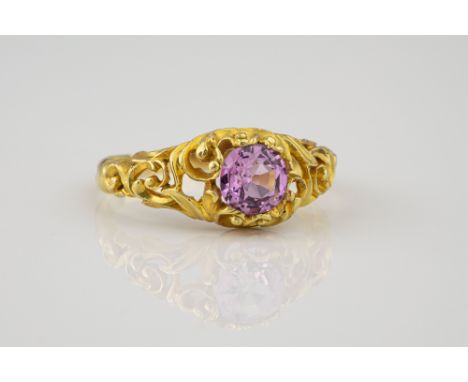 A Victorian 18ct gold and pink topaz ring, the round cut topaz within an open scrollwork setting, size O.