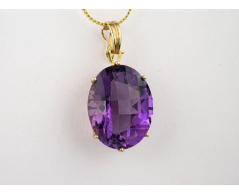 A 9ct yellow gold and amethyst pendant, the 25 x 20mm. oval cut amethyst with a facet cut face, within a deep basket setting 