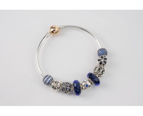 A Pandora sterling silver Moments bangle, fitted with nine silver and Murano glass charms, the silver charms set with CZ, in 