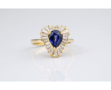 An 18ct yellow gold, sapphire and diamond cluster ring, the pear cut 1.3ct sapphire within a frilled border of tapered baguet