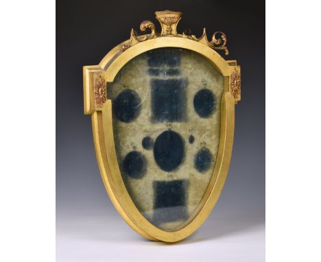 A Regency style giltwood portrait miniature display case, 19th century, the glazed case of shield form, with urn and scrolled