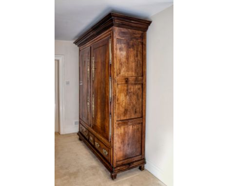 An imposing French 18th century oak armoire, with fine colour, the flared cornice over a pair of doors with large decorative 