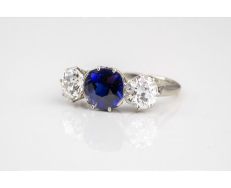 A good antique platinum, sapphire and diamond three stone ring, early 20th century, the central 9mm. round cut sapphire flank