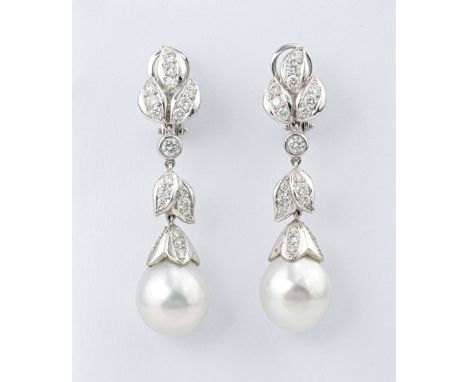 A pair of 18ct white gold, South Sea pearl and diamond drop earrings, the single 13mm. pearls suspended from foliate decorate