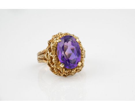 A vintage 9ct yellow gold and amethyst ring, hallmarked London 1972, the 14 x 10mm. oval cut amethyst raised over a tiered wa