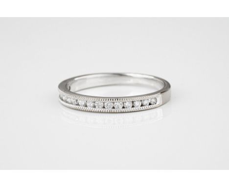 A platinum and diamond half eternity ring, channel set with sixteen brilliant cut diamonds within millegrain borders, ring si