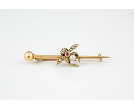An antique 15ct gold, ruby and seed pearl bee brooch, the gem set bee on a plain pin with ball terminal, 40mm. long.