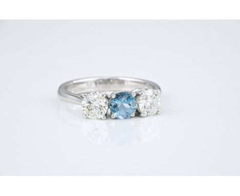 An 18ct white gold, aquamarine and diamond three stone ring, the 0.52ct round cut aquamarine flanked by a pair of brilliant c