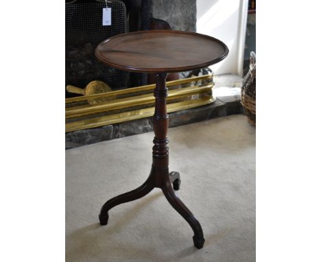 A mid-19th century mahogany tripod table, the circular dished top on a turned baluster column, to swept supports with spade f