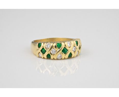 A 14ct yellow gold, emerald and diamond ring, with alternate diagonal rows of round cut emeralds and brilliant cut diamonds w