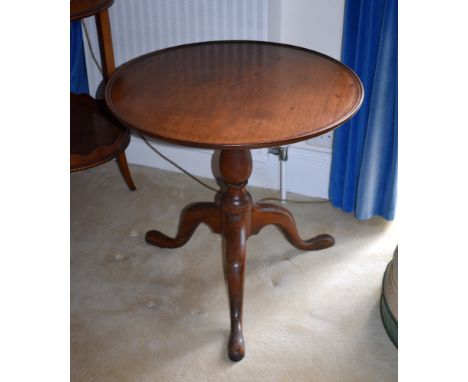 A George III mahogany tilt-top tripod table, reduced in height, the dished circular top on a turned baluster column, on three