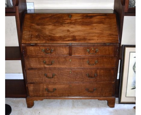 A George III mahogany bureau, with fitted interior and baize writing surface, over two short and three long graduated drawers