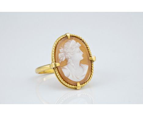 A French 18ct yellow gold cameo ring, the carved shell cameo of a classical maiden within a rope twist border, size R.