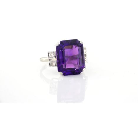 An Art Deco 18ct white gold, amethyst and diamond five stone ring, the large 14.5 x 12mm. emerald cut amethyst flanked by pai