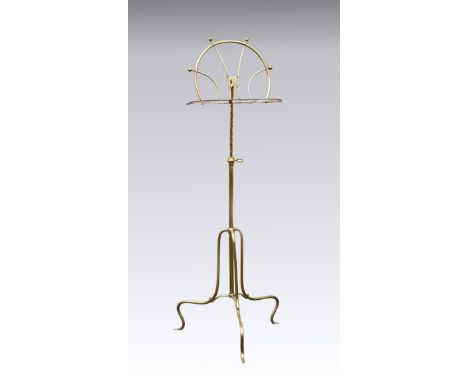 A late Victorian adjustable turned brass music stand, the shaped rest on a revolving pivot, raised on tripod stand, 41¼in. (1