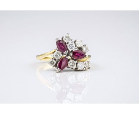 An 18ct yellow gold, ruby and diamond floral design ring, set with three marquise cut rubies and nine graduated brilliant cut