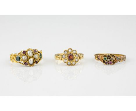 Three antique gold, gemstone and seed pearl rings, comprising an 18ct gold, ruby and seed pearl floral cluster ring, hallmark