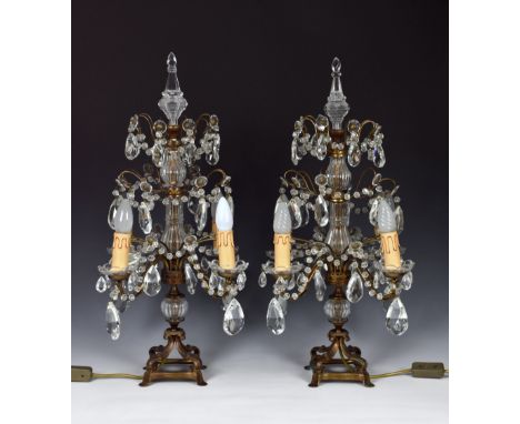 A pair of cut glass and gilt metal four light candelabra in Louis XV style, 20th century, the cut glass sconces above scrolle