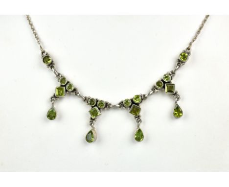 A silver and peridot fringe necklace, set with round, square and pearl cut peridots, 16½in. (42cm.) long.