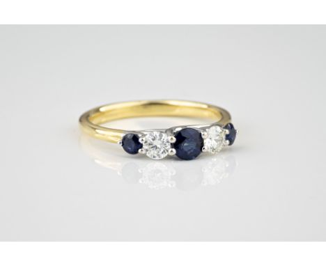 An 18ct yellow and white gold, sapphire and diamond five stone ring, the three graduated round cut sapphires, total 0.54ct, d