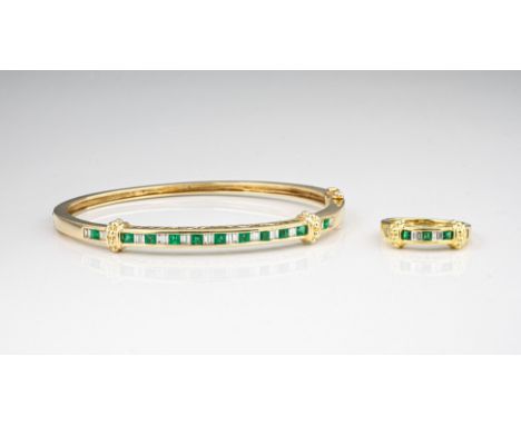 A 14ct gold, emerald and diamond bangle, the bangle with two beaded collars and channel set with alternate pairs of baguette 