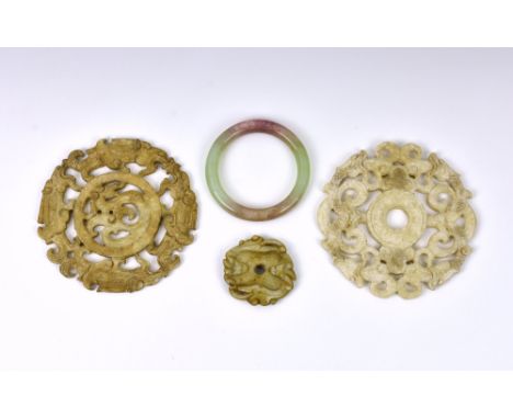 Two Chinese carved jade style hardstone discs, with pierced design featuring dragons, 4 5/8in. (14.3cm.) diameter, together w