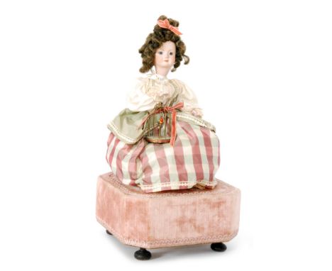 A mid 20th Century or later Swiss automaton of a bisque head girl holding a bird in a cage which moves together with her head