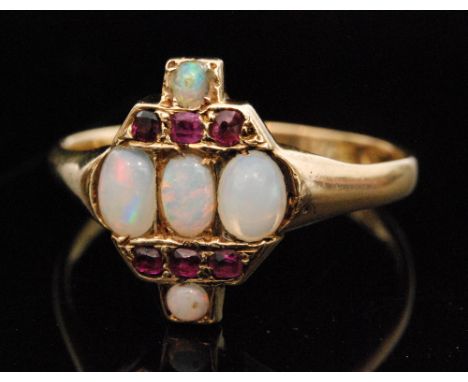 An Art Deco 18ct hallmarked opal and ruby cluster ring, three central opals with three further rubies set above and below, in