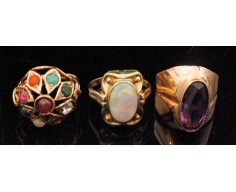 Three gem set dress rings to include a Russian 14ct rose gold and amethyst ring, a synthetic opal ring stamped 333, and a mul