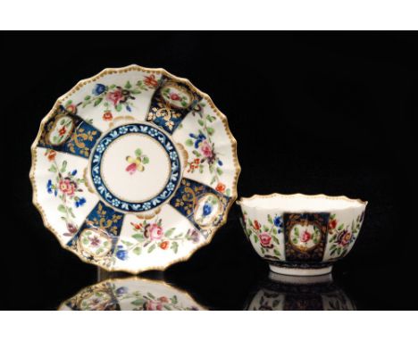 An 18th Century Worcester fluted teabowl and saucer decorated with alternate floral prays between blue and gilt panels, paint