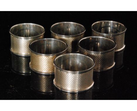 A set of six hallmarked silver circular napkin rings each with engine turned decoration and individually boxed, Birmingham 19