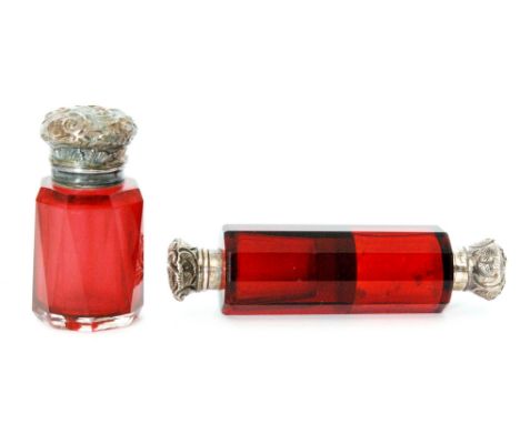 A Victorian double ended scent bottle, the slice cut ruby glass body with embossed foliate covers, unmarked, together with an