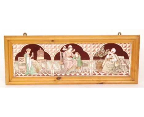 A framed tile panel comprising three 8in dust pressed tiles each with hand painted decoration with Medieval ladies, the first