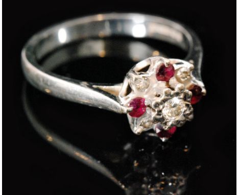 A 1970s hallmarked 18ct white gold ruby diamond ring, the central brilliant cut diamond illusion set above a ruby and diamond