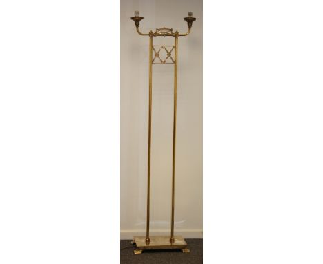 An early 20th Century brass twin light standard lamp, the rectangular base on four bracket feet supporting two tubular column
